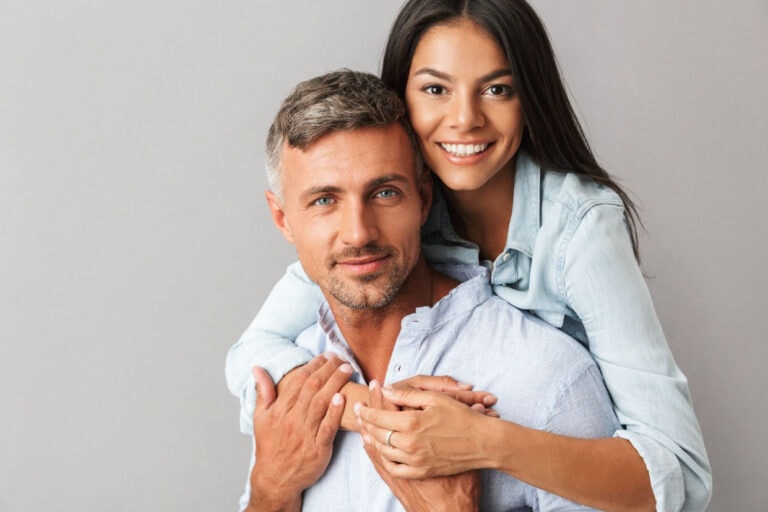 A happy, healthy-looking couple smiling and embracing, representing the positive effects of bioidentical hormone replacement therapy on overall well-being.